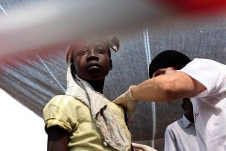 Seorang anak perempuan sedang mendapatkan suntikan vaksinasi campak dari seorang petugas Medecins Sans Frontier (MSF) di sebuah kamp pengungsi di ibu kota Republik Afrika Tengah, Bangui.