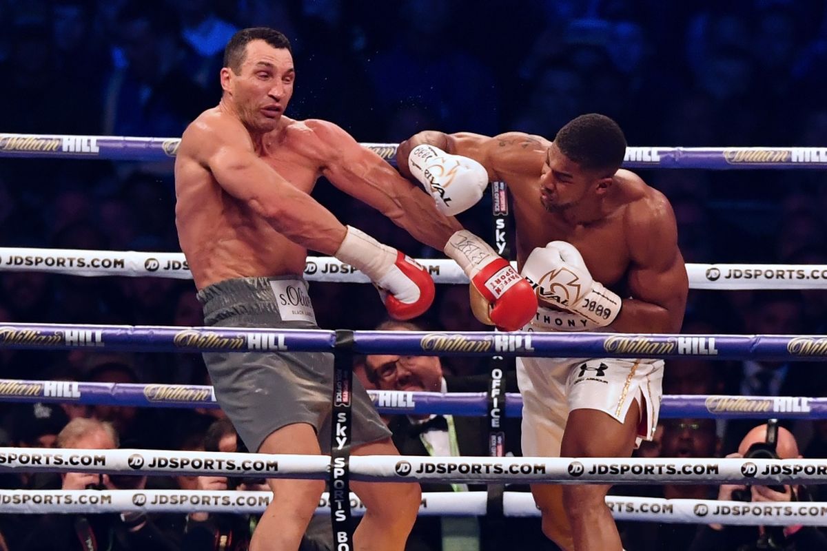 Petinju Inggris, Anthony Joshua (kiri), melancarkan pukulan ke arah petinju Ukraina, Wladimir Klitschko, pada ronde keempa pertandingan kelas berat di Wembley Stadium, London, Sabtu (20/4/2017).