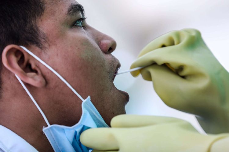 Petugas analis laboratorium mengambil sampel swab lendir tenggorokan dan hidung di halaman parkir selatan, Gelora Bung Karno, Jakarta Pusat, Rabu (20/5/2020). Bank Negara Indonesia (BNI) menggelar kegiatan berupa layanan swab test gratis untuk cegah pandemi yang diakibatkan oleh virus corona (SARS-CoV-2) untuk masyarakat umum dan perawat di Jakarta.