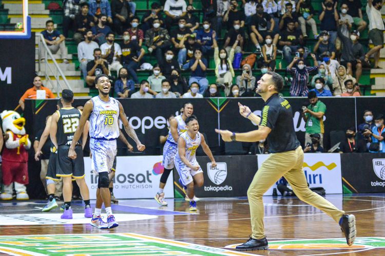 Pelatih Prawira Bandung David Singleton berlari ke tengah lapangan merayakan kemenangan begitu gim ketiga Playoff Indonesian Basketball League (IBL) 2022 Prawira Bandung vs Dewa United Surabaya selesai pada Selasa (16/8/2022) di Gor C-Tra Arena.