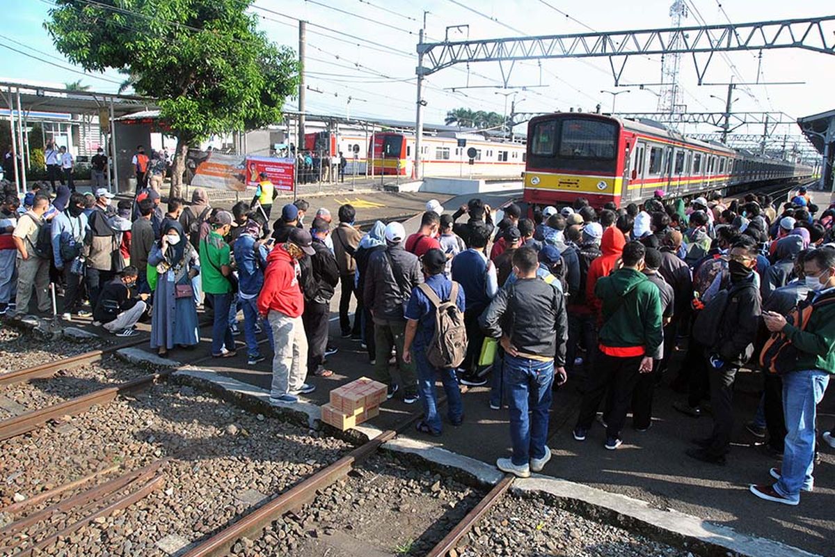 Sejumlah penumpang KRL Commuter Line antre menunggu kedatangan kereta di Stasiun Bogor, Jawa Barat, Senin (13/4/2020). Antrean panjang penumpang KRL Commuter Line di Stasiun Bogor tersebut akibat kebijakan pemeriksaan suhu tubuh dan pembatasan jumlah penumpang di setiap rangkaian kereta sebagai tindakan pencegahan penyebaran wabah pandemi virus Corona (COVID-19).