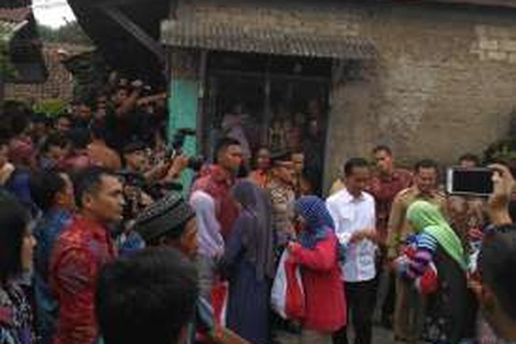 Presiden Joko Widodo menyaksikan pembagian sembako kepada warga di Panaragan, Bogor, Jawa Barat, Selasa (28/6/2016).
