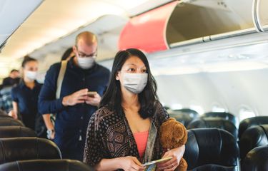 Ilustrasi penumpang pesawat mengenakan masker.