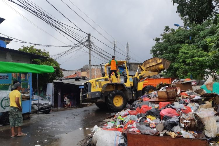 Alat berat yang sedang mengangkut sampah ke truk di Jalan Inpeksi Mookevart, Daan Mogot, Jakarta Barat, Jumat (10/1/2020) 