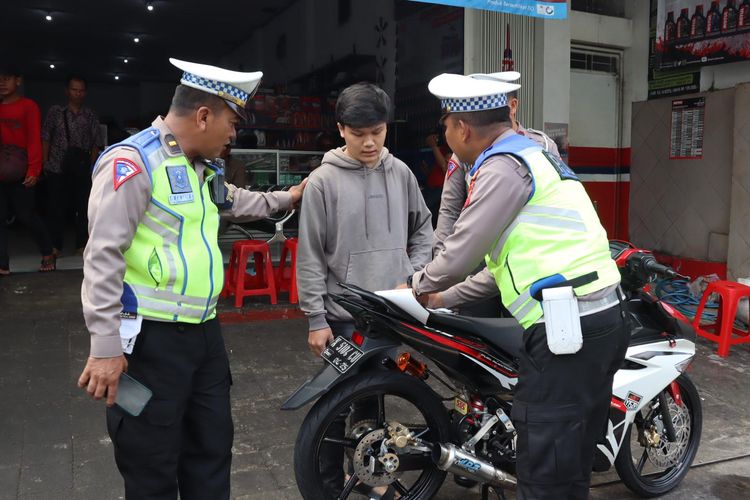Petugas menilang pengguna sepeda motor yang menggunakan knalpot brong