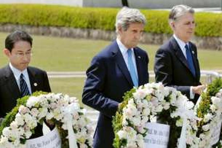 Menlu AS John Kerry diapiti Menlu Jepang Fumio Kishida (kiri) dan Menlu Inggris Philip Hammond (kanan).