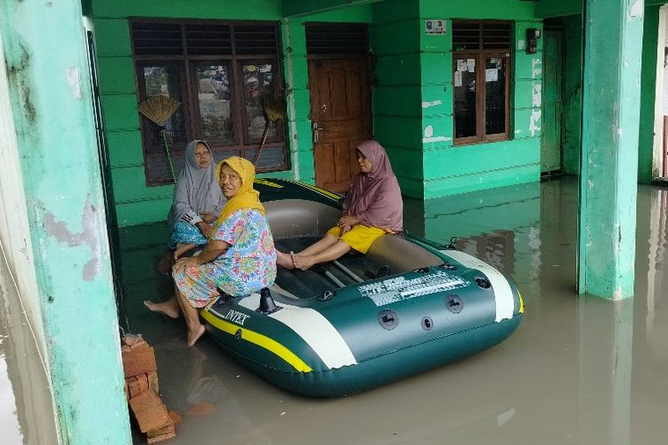 Warga menaiki perahu karet setelah rumahnya terendam banjir di Kelurahan Sumurpanggang, Kecamatan Margadana, Kota Tegal, Jawa Tengah, Kamis (2/3/2023).