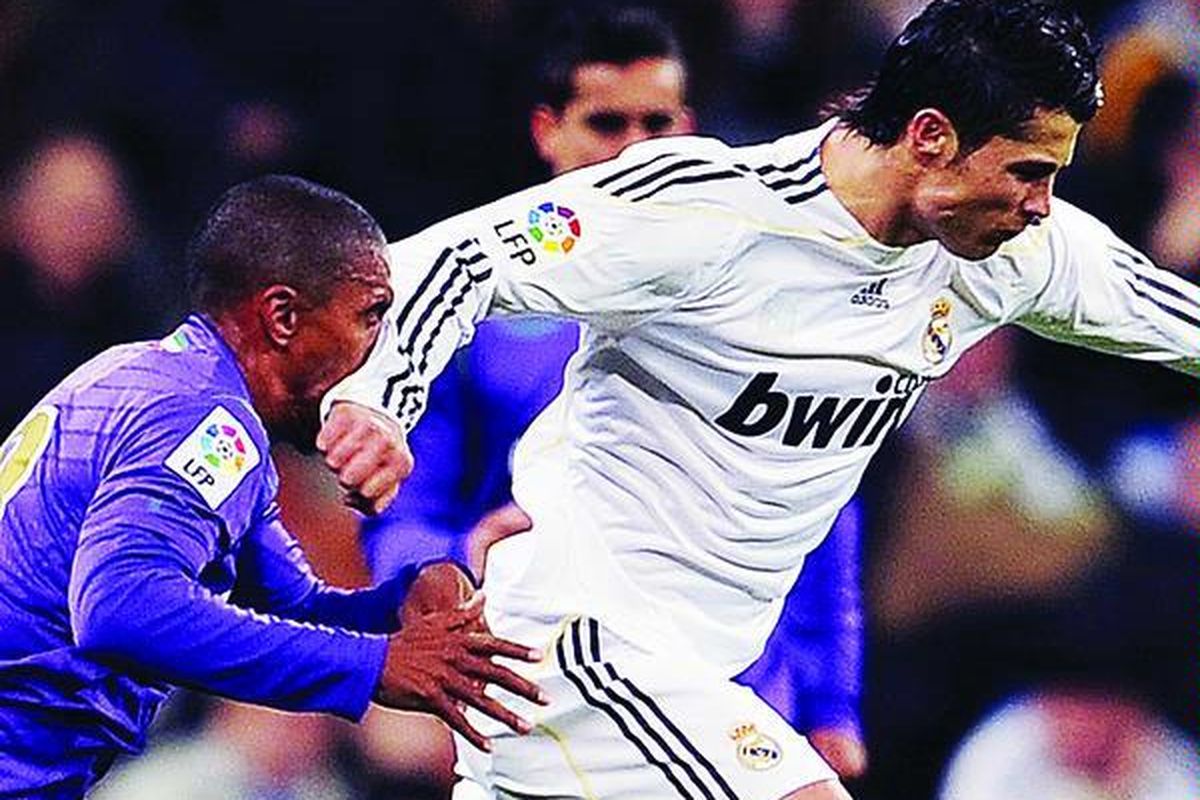 Gelandang Real Madrid, Cristiano Ronaldo ( kanan), mendaratkan tangannya ke wajah pemain Malaga, Patrick Jan Mtiliga, dalam laga Liga Spanyol di Stadion Santiago Bernabeu, Madrid, Spanyol, Minggu (24/1). Madrid menang 2-0.