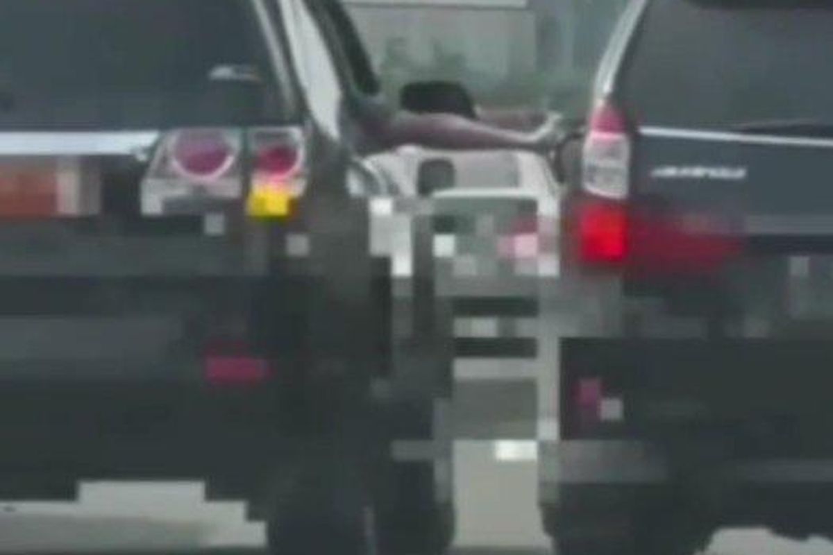 Tangkapan layar rekaman video viral pengemudi mobil berpelat dinas saat menodongkan senjata api kepada pengendara mobil pribadi di Tol Jagorawi, Minggu (18/9/2022)