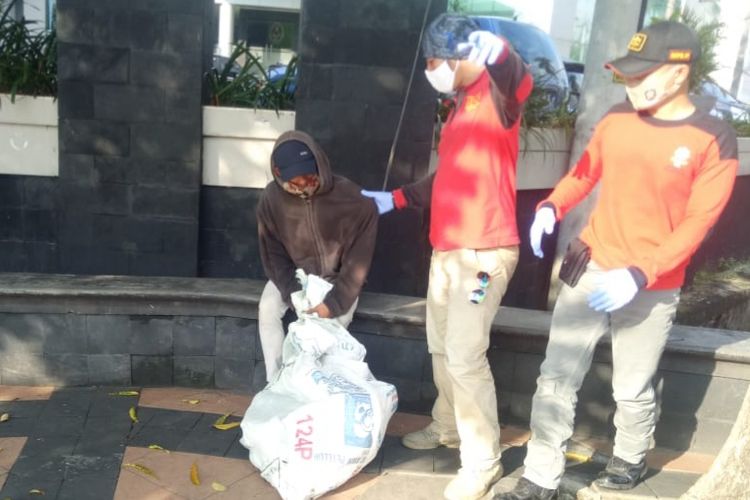 Petugas Satpol PP saat menertibkan salah satu manusia karung di tepi jalanan Semarang, Selasa (19/5/2020).