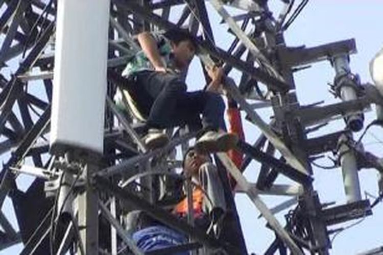 Petugas SAR mencoba mengevakuasi Roy yang memanjat tower seluler, Selasa (26/11/2013). 