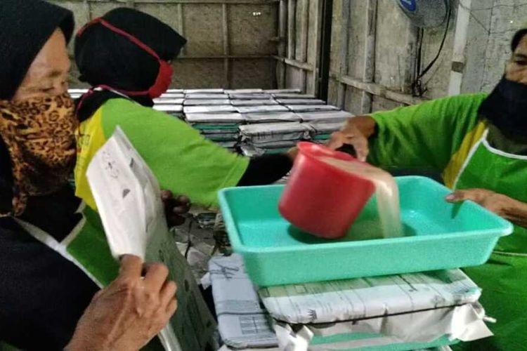 Karyawan sedang mengolah air kelapa hasil fermentasi untuk dijadikan nata de coco.