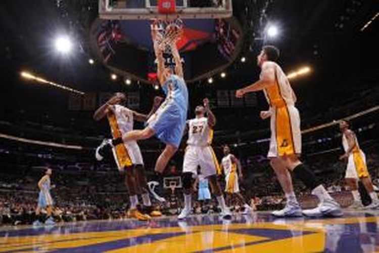 Pemain Denver Nuggets, Timofey Mozgov (tengah) melakukan dunk saat timnya bertemu Los Angeles Lakers pada lanjutan kompetisi NBA yang berlangsung di Staples Center, Minggu (05/01/2014).