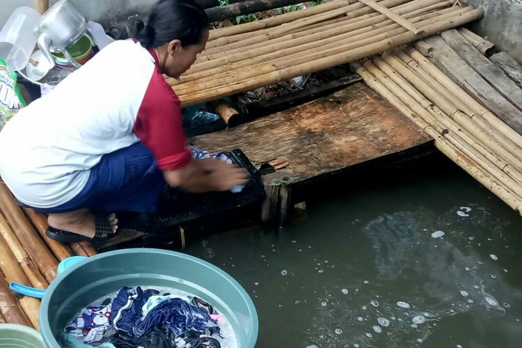 Aliyah (47), warga Koceak, Keranggan, Setu, Tangerang Selatan sedang melakukan cuci baju dengan menggunakan air kali Cisalak, Selasa (8/10/2019). Ini dilakukan setelah mengalami kekeringan air bersih selama 4 bulan.