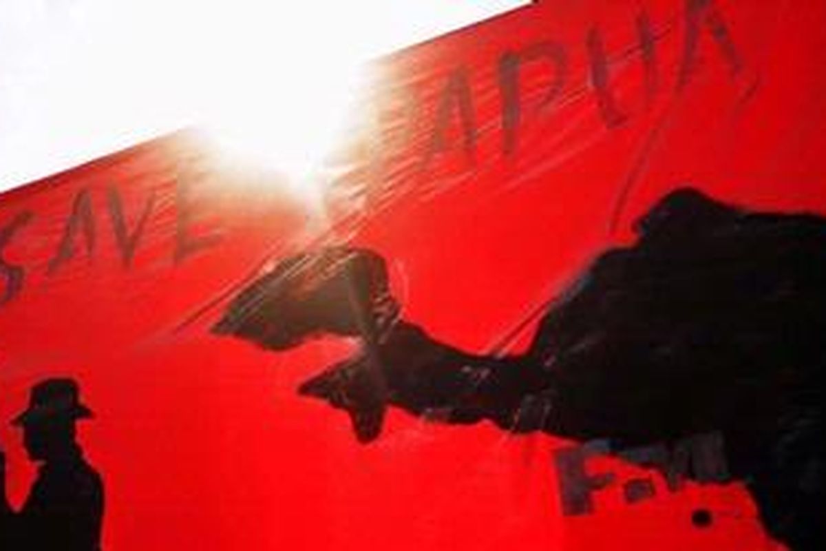 Demonstran membentangkan spanduk 