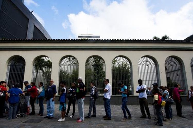 Warga kota Caracas, Venezuela rela antre berjam-jam di sebuah bank untuk menukar uang pecahan 100 bolivar yang akan dihapus pemerintah.