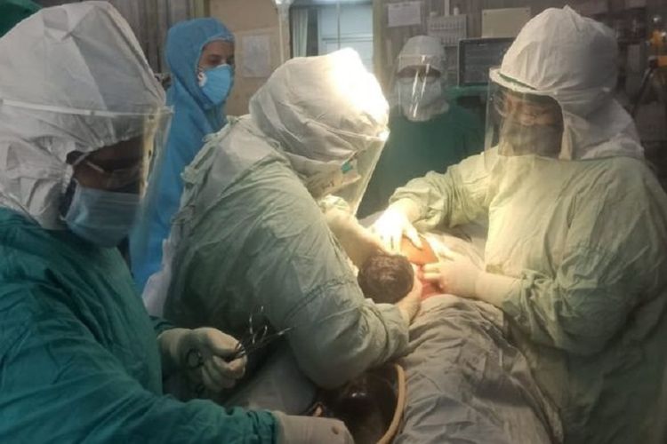 Dokter dan perawat di Rumah Sakit Lokmanya Tilak, Mumbai, India, ketika membantu kelahiran seorang bayi. Rumah sakit itu membantu kelahiran lebih dari 100 bayi dar ibu yang positif Covid-19