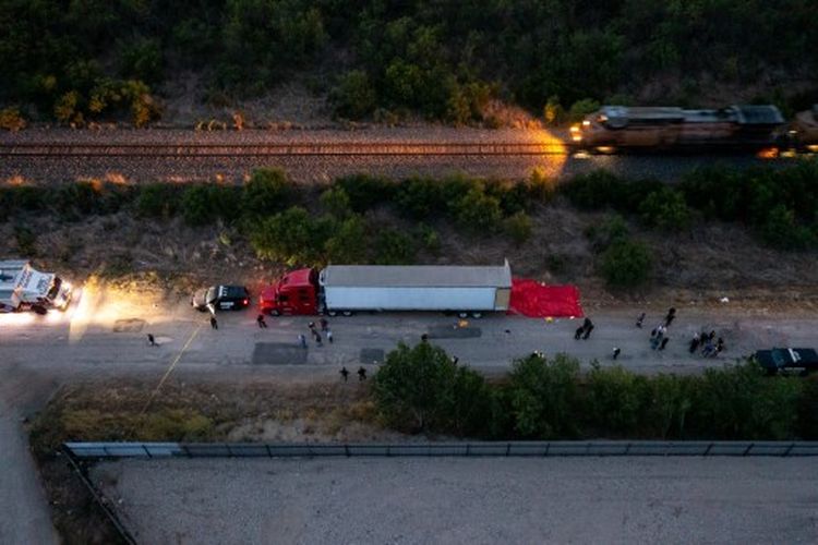 Dalam tampilan udara ini, anggota penegak hukum menyelidiki trailer traktor pada 27 Juni 2022 di San Antonio, Texas. Menurut laporan, setidaknya 46 orang, yang diyakini sebagai pekerja migran dari Meksiko, ditemukan tewas di sebuah trailer traktor yang ditinggalkan. Lebih dari selusin korban ditemukan hidup, menderita serangan panas dan dibawa ke rumah sakit setempat. 