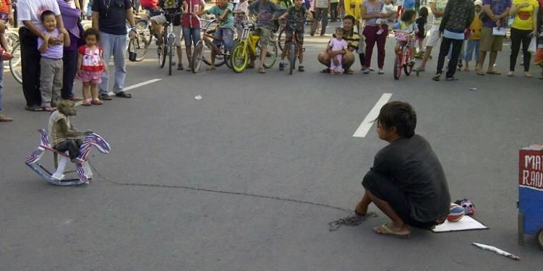 Atraksi topeng monyet saat hari bebas kendarabn bermotor di salah satu jalan di Semarang, Minggu (17/3/2013).