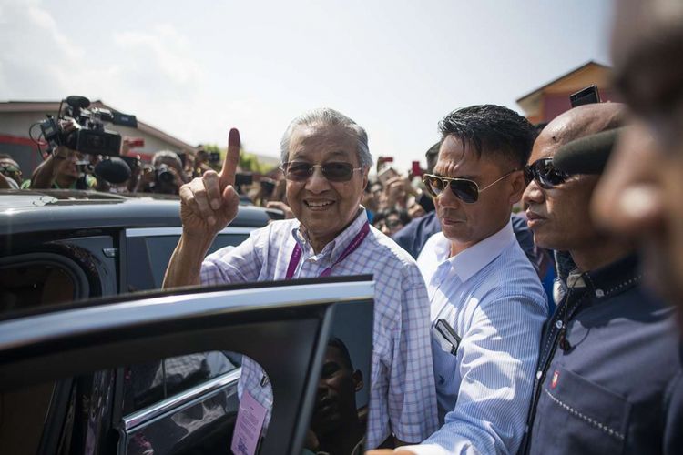 Politisi senior Malaysia, Mahathir Mohamad dari koalisi Pakatan Harapan, menyapa sejumlah pendukungnya setelah memberikan suaranya dalam pemilhan umum, di tempat pemungutan suara di Alor Setar, Malaysia, Rabu (9/5/2018). Pemilu yang berlangsung hari ini menjadi pertarungan sengit Perdana Menteri Petahana Najib Razak, dan mantan PM Mahathir Mohamad.