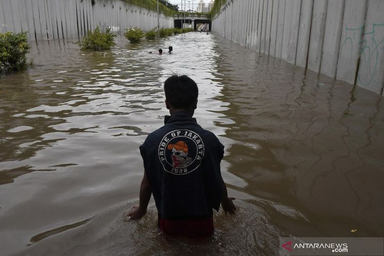 Anak-anak bermain air di terowongan Jalan Angkasa yang terendam banjir, Kemayoran, Jakarta Pusat, Selasa (25/2/2020). Hingga Selasa (25/2) sore sejumlah kawasan di Ibu kota masih terendam banjir.