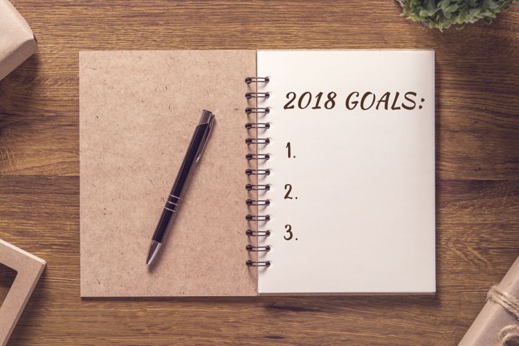 2018 goals list in notebook with gift box new year on wooden table background.