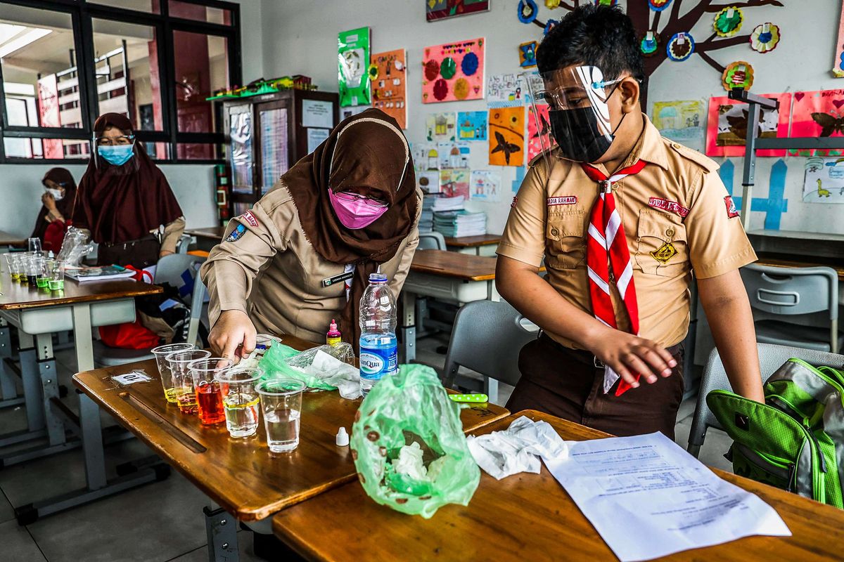 Guru memberikan materi pelajaran kepada murid saat uji coba pembelajaran tatap muka pada hari pertama di SDN 03 Palmerah, Jakarta Barat, Rabu (7/4/2021). Pembelajaran tatap muka (PTM) di wilayah PPKM level 3 Jawa-Bali masih mengacu Surat Keputusan Bersama (SKB) 4 Menteri tentang Panduan Penyelenggaraan Pembelajaran pada Masa Pandemi Covid-19 dengan menggelar PTM terbatas dengan jumlah peserta didik 50 persen dari kapasitas ruang kelas dan pembelajaran jarak jauh (PJJ).