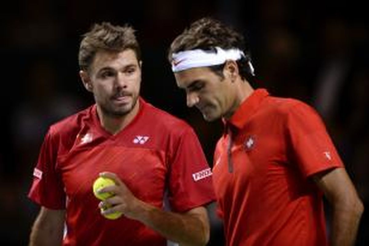 Petenis Swiss Stanislas Wawrinka (kiri) dan Roger Federer berdiskusi saat menghadapi ganda Kazakhstan, Andrey Golubev/Aleksansdr Nedovyesov, pada perempat final Davis Cup, Sabtu (5/4/2014). Federer/Wawrinka kalah 4-6, 6-7(5), 6-4, 6-7(5).