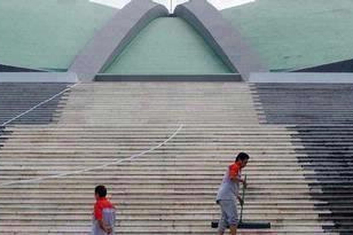 Petugas tengah membersihkan kompleks Gedung DPR, Senayan, Jakarta.