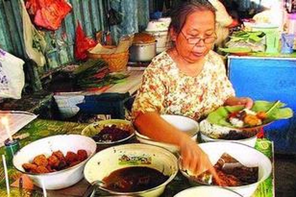 Bu As, juru masak warung nasi jamblang Bu Marni, sibuk melayani pembeli Nasi Jamblang Bu Marni.
