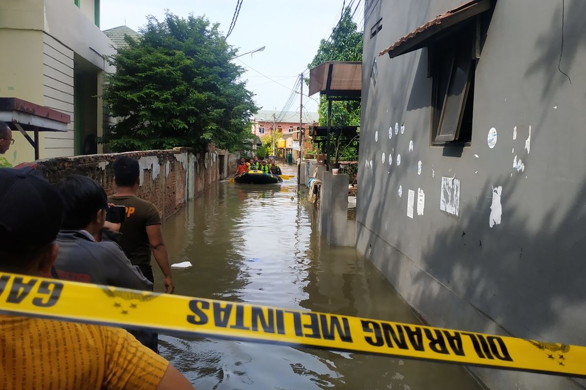 Petugas gabungan menumpangi perahu karet mencari AB (11) bocah yang hilang terbawa arus Kali Kapuk di Kelurahan Kalibaru, Kota Bekasi saat banjir melanda, Kamis (2/1/2020).