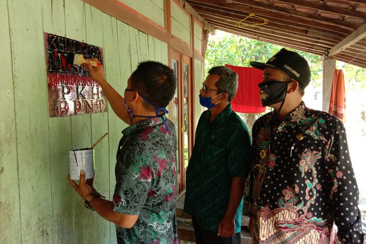 Perangkat Desa Kunir Kecamatan Dempet Kabupaten Demak Jawa Tengah melakukan pengecapan tanda PKH di rumah rumah yang terdata sebagai keluarga miskin , Selasa (5/5/2020)