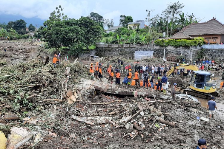 Petugas gabungan saat membersihkan sisa material banjir di Dusun Gintung, Desa Bulokerto, Kecamatan Bumiaji, Kota Batu, Jumat (5/11/2021).