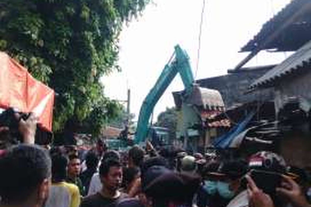 Dua alat berat mulai bergerak masuk ke dalam pemukiman Bukit Duri di RT 06 RW 12, Tebet, Jakarta Selatan, Rabu (28/9/2016). Alat berat tersebut langsung membongkar rumah warga.