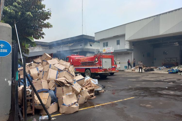 Sebagian paket yang dikemas fengan kardus tampak menumpuk di depan pintu gerbang gudang JNE setelah pegawai berhasil menyelamatkannya.