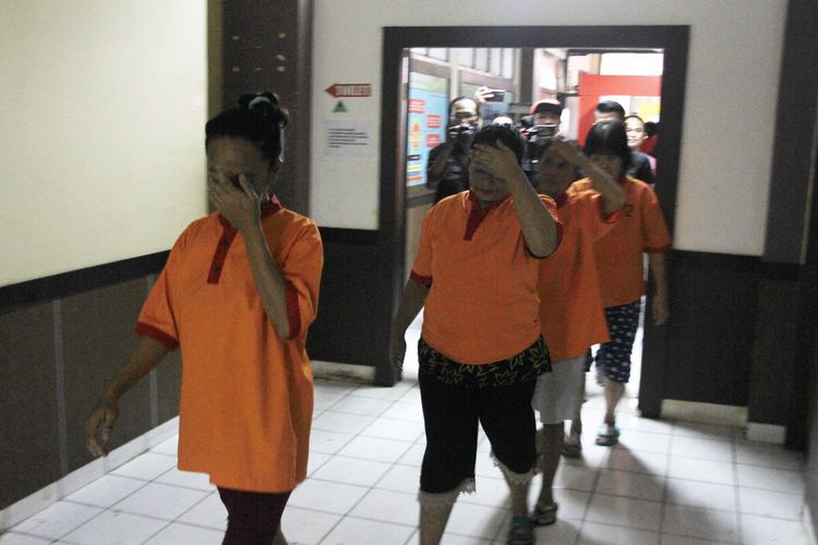Tersangka Darmini (44) ibu yang tega menjual anak yang baru dilahirkannnya saat di giring ke Polrestabes Palembang, Senin (20/1/2020).