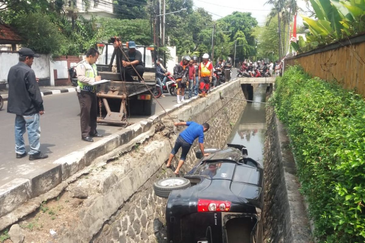 Sebuah mobil Daihatsu Xenia terperosok di Jalan Darmawangsa, Jakarta Selatan, Sabtu (8/9/2018)