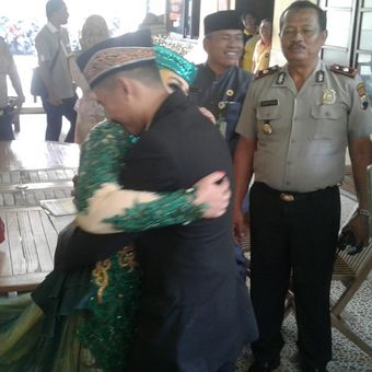 Pasangan suami istri, Aditya dan Ratri, berpelukan seusai melangsungkan pernikahan di Mapolsek Laweyan, Solo, Jawa Tengah, Jumat (26/1/2018).