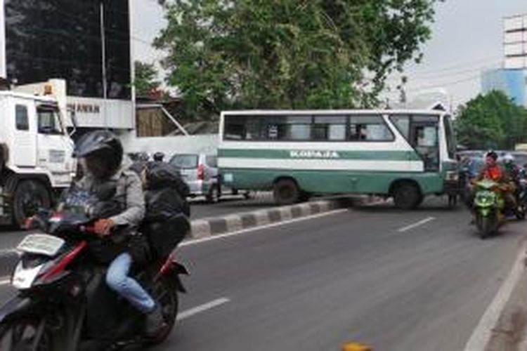 Kopaja 502 jurusan Kampung Melayu-Tanah Abang melintang di median jalan Brigjend Katamso, Jakarta Barat, Sabtu (21/6/2014). Akibatnya arah Tanah Abang-Kemanggisan macet total dan sebaliknya.