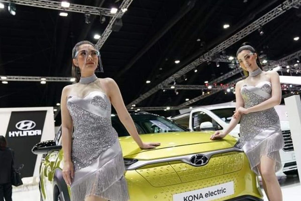 Model di BIMS 2020 mengenakan face mask ketika tampil bersama mobil yang dipamerkan selama pameran.