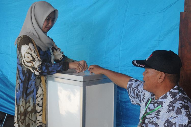 Foto dirilis Selasa (2/7/2019), menunjukkan warga memasukan kertas barcode seusai memilih calon kepala desa pada Pemilihan Kepala Desa (Pilkades) berbasis elektronik atau e-voting di Kantor Desa Bendosari, Sawit, Boyolali, Jawa Tengah. Boyolali menjadi salah satu daerah di Indonesia yang mengimplementasikan teknologi melalui sistem pemungutan suara secara elektronik atau e-voting.