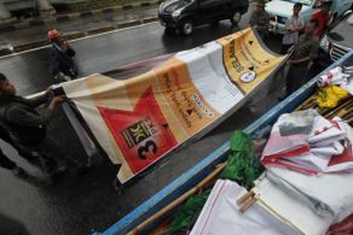 Petugas Satpol PP bersama Badan Pengawas Pemilu DKI menertibkan atribut kampanye calon anggota legislatif di jalan-jalan protokol di Jakarta, Rabu (8/1/2014). Atribut kampanye diturunkan karena tidak sesuai jadwal kampanye caleg untuk Pemilu 2014 yang telah ditetapkan.