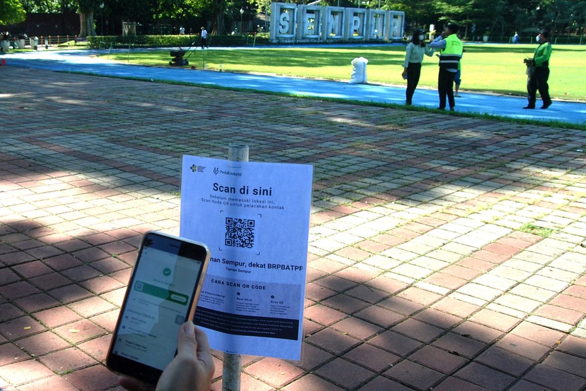 Warga memindai kode QR pada aplikasi PeduliLindungi saat masuk Taman Sempur di Kota Bogor, Jawa Barat, Senin (14/3/2022). Pemerintah Kota Bogor mulai membuka kembali taman publik secara terbatas dengan penerapan protokol kesehatan ketat dan kapasitas pengunjung maksimal 75 persen seiring pemberlakuan PPKM level 2 di wilayah aglomerasi Jabodetabek. ANTARA FOTO/Arif Firmansyah/rwa.