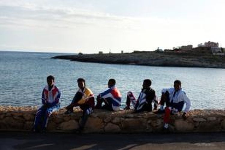 Para pencari suaka dari Afrika tengah bersantai di pelabuhan pulau Lampedusa, Italia. Pulau kecil ini menjadi tujuan para pencari suaka Afrika yang ingin masuk ke Eropa.