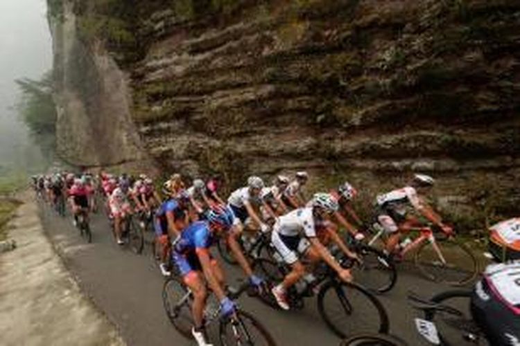 Para pebalap melintasi Tebing Harau, Kecamatan Harau, Kabupaten Lima Puluh Kota, Provinsi Sumatera Barat, dalam etape kelima Tour de Singkarak, Rabu (7/10/2015). Dalam etape ini, para pebalap menempuh jarak 164 kilometer.