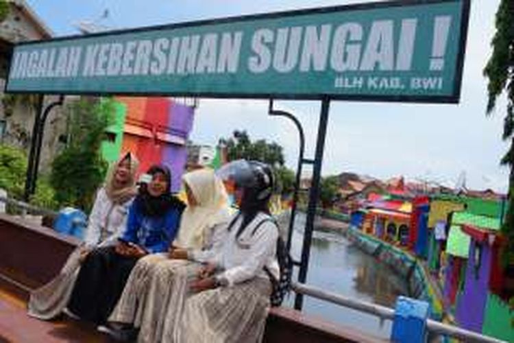 Siswa sekolah sedang foto berlatar belakang kampung warna warni di bantaran sungai Kali Lo Banyuwangi Kamis (24/11/2016)