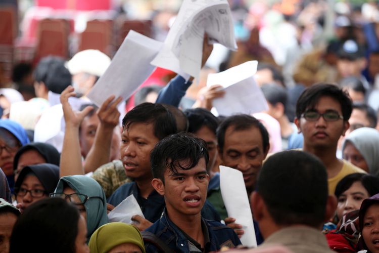 Warga antre menyerahkan berkas untuk pencetakan e-KTP di stan pelayanan dan pencetakan e-KTP di Taman Mini Indonesia Indah (TMII), Jakarta, Jumat (20/10/2017).  Kegiatan yang digelar antara Dinas Kependudukan dan Catatan Sipil DKI bekerja sama dengan Direktorat Jenderal Kependudukan dan Catatan Sipil Kementerian Dalam Negeri ramai diserbu warga yang yang belum memiliki e-KTP. KOMPAS IMAGES/KRISTIANTO PURNOMO
