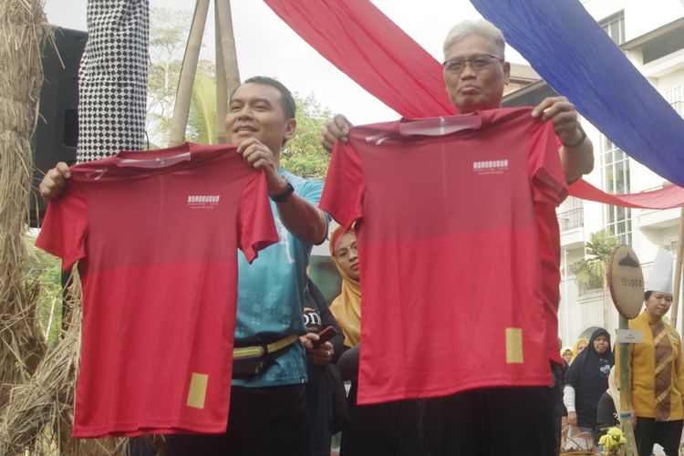 Redaktur Pelaksana Harian Kompas, Adi Prinantyo (kiri) dan Direktur Utama Bank Jateng, Supriyatno memperkenalkan jersey untuk pelari di Borobudur Marathon, Minggu (6/10/2019) pagi.