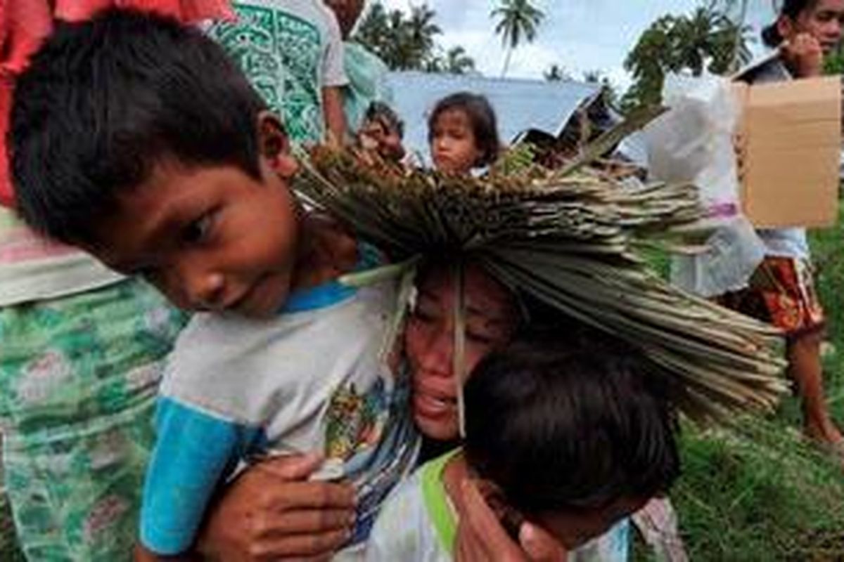 Seorang ibu menangis memeluk putranya saat bertemu kembali setelah terpisah saat bencana tsunami menimpa di Kampung Taparaboat, Kepulauan Metawai, Sumatera Barat, Kamis (28/10/2010).