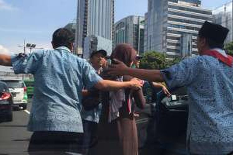 Seorang ibu yang sedang menggendong balita dipaksa keluar dari taksi yang ditumpanginya